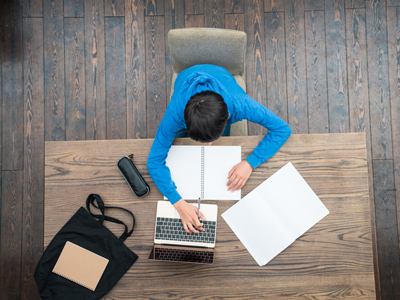 Boy writing a research project with notebook