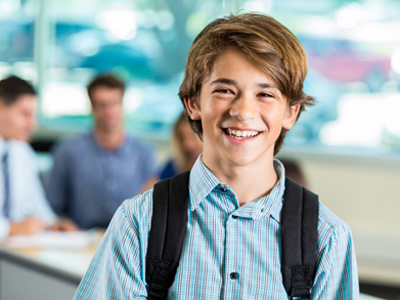Confident and happy teenage boy at school