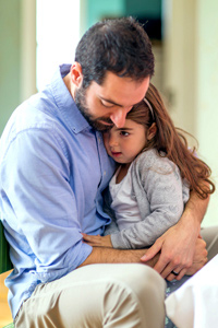 Parent comforting and supporting his upset daughter